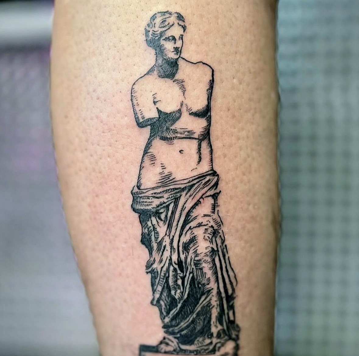 Fine line Venus de Milo statue tattoo on the calf
